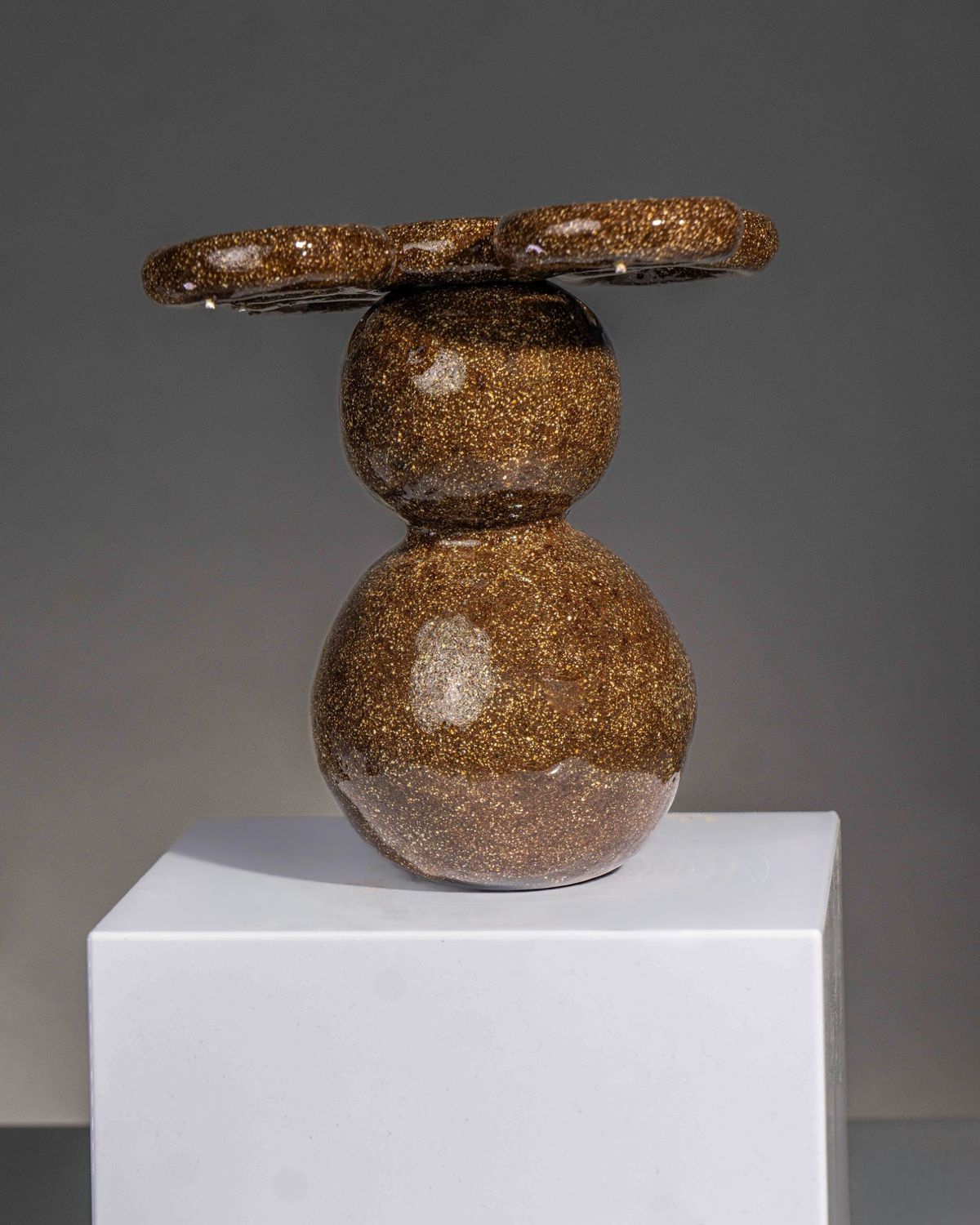 Speckled brown glazed form of two stacked spheres topped with a ring-shaped disc